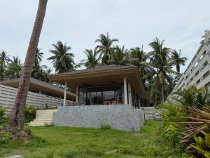 a building with palm trees in front of it at Wave Villa New 2BR Pool Villa in Ko Phangan