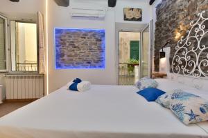 a bedroom with a large white bed with blue pillows at Mezza Galea in Vernazza