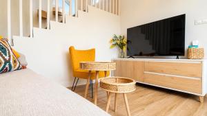 a bedroom with a tv and a bed and a table at O Retiro da Costa Galitrips in Muxia