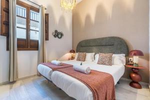 a bedroom with a large bed and a chandelier at BnS Dauro Suites in Granada