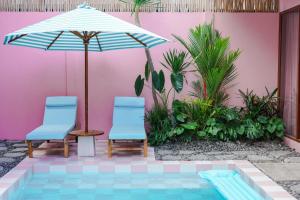 two chairs and an umbrella next to a pool at Hyde Boutique Hotel in Kuta Lombok