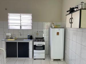 a kitchen with a stove and a white refrigerator at Apartamento em Seabra in Seabra +8 photos