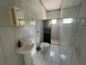 a white bathroom with a sink and a toilet at Apartamento em Seabra in Seabra