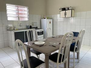 a kitchen with a wooden table with chairs and a refrigerator at Apartamento em Seabra in Seabra