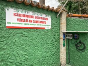 a sign on the side of a green wall at Villa'l Mare Hotel in Maresias +104 photos