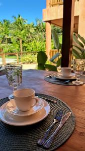 a table with a cup and a plate on a table at Vila Anambé in Uruçuca