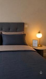 a bedroom with a bed with a lamp on a table at Vega Suite in Bracciano
