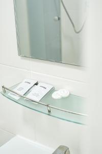 a glass shelf in a bathroom with a mirror at Алматы Транзит №1 in (( Turksib ))