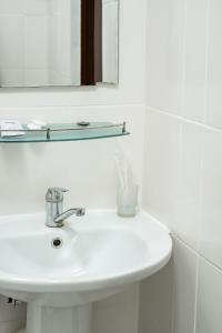 a white sink in a bathroom with a mirror at Алматы Транзит №1 in (( Turksib ))