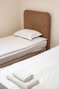 two beds in a room with white sheets and towels at Алматы Транзит №1 in (( Turksib ))