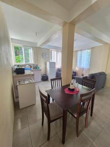 a kitchen and dining room with a table and chairs at Barefoot Apartments in Roseau