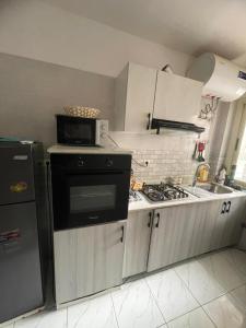 a small kitchen with a stove and a microwave at The Sonu Nest in Dakar