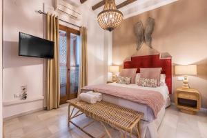 a bedroom with a large bed and a tv at BnS Dauro Suites in Granada +74 photos
