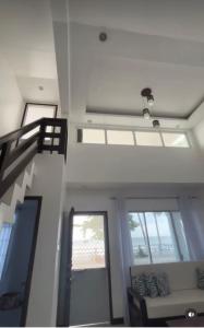 a room with a staircase and a couch and windows at Lui my happy place in Pandan