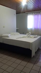 a large bed in a room with a window at Pousada recanto nordestino in Caucaia