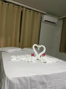 two swans making a heart on a bed at Pousada recanto nordestino in Caucaia