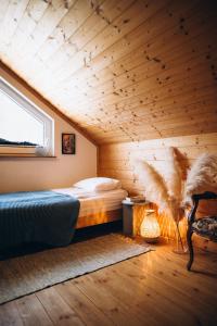 a bed in a room with a wooden ceiling at Siedlisko Rogówko in Rogówko