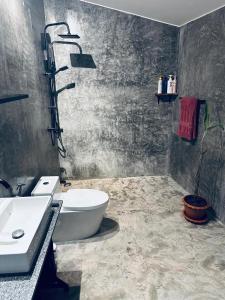a bathroom with a white toilet and a sink at Loft at Rawaï Beach in Nai Harn Beach