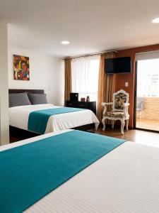 a hotel room with two beds and a chair at Hotel Posada Leon in Pasto