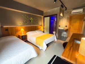 a hotel room with two beds and a bathroom at Villa'l Mare Hotel in Maresias