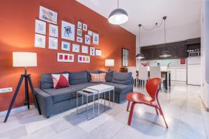 a living room with a blue couch and a kitchen at BnS Dauro Suites in Granada