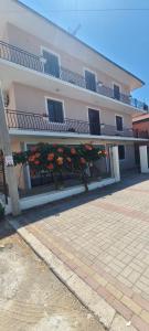 a large pink building with flowers in front of it at ℰ`ℋ Hotel - Velipoje rruga nr 7 in Velipojë