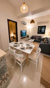 a living room with a white table and chairs at غرفتين وصالة شقق ديما الفندقية in Abha