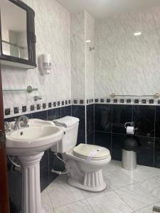 a bathroom with a toilet and a sink at Hotel Posada Leon in Pasto +21 photos
