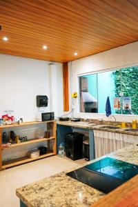 a kitchen with a sink and a large window at Sea Wolf Surf Hostel Campeche in Florianópolis