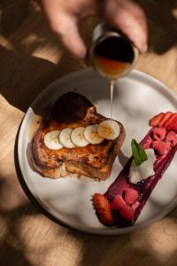 a plate of food with toast and fruit and a glass of wine at Salara Boutique Hotel & Villas Todos Santos in Todos Santos
