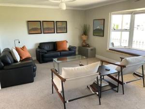a living room with couches and a table at Fletcher House Sleeps 18 Location Views in Taupo