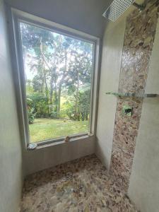 a bathroom with a large window and a shower at Seven on the Hillside in Pacific Harbour