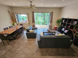 a living room with a couch and a dining room at Seven on the Hillside in Pacific Harbour