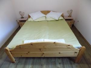 Apartment Zeleni dragulj Pohorje في Oplotnica: سرير خشبي في غرفة بها مواقف ليلتين