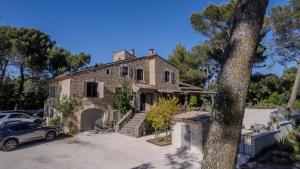 an old stone house with a car parked in front at LA BASTIDE De La Colline in Cavaillon