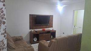 a living room with two couches and a flat screen tv at Morada Santa Rita in Aparecida