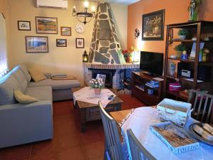 a living room with a couch a table and a fireplace at Casa Rural Dani. Escalona in Toledo
