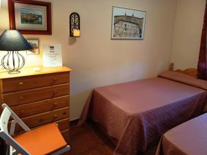 a bedroom with a bed and a dresser and a lamp at Casa Rural Dani. Escalona in Toledo