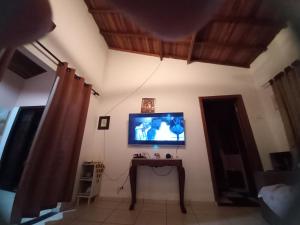 a living room with a tv and a table with a table at Chalé casa na mata Jasmim in Guararema +19 photos