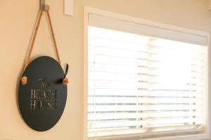 a window with a sign that reads the beagle house at Tideview Cottage - Incredible Views - Tairua in Tairua