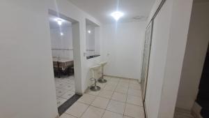 a white hallway with a bathroom with a sink at Morada Santa Rita in Aparecida +10 photos