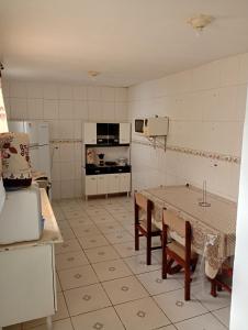 a kitchen with a table and a stove and a refrigerator at Morada Santa Rita in Aparecida
