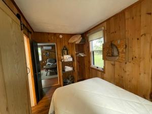 a bedroom with wooden walls and a bed in a room at Tracadie Cottages in York