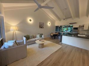 a living room with a couch and a table at Stylish Tropical Villa with Lagoon Pool in Port Douglas