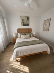 a bedroom with a large bed and two lamps at Stylish Tropical Villa with Lagoon Pool in Port Douglas