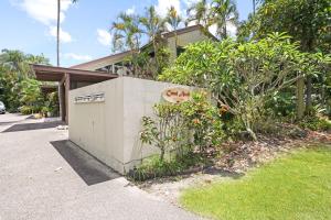 a house with a retaining wall next to a yard at Stylish Tropical Villa with Lagoon Pool in Port Douglas