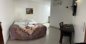 a bedroom with a bed and a table in it at Querência Pantaneira in Miranda
