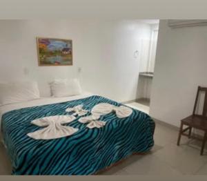 a bedroom with a bed with a blue and white blanket at Querência Pantaneira in Miranda +1 photo