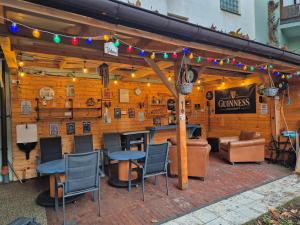 a bar with chairs and tables and lights on a wall at JÓKAI Apartman in Komárno