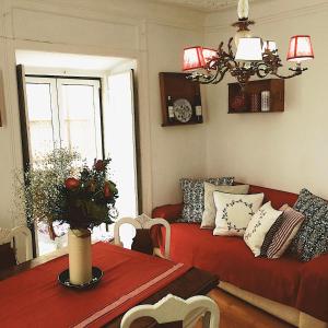 uma sala de estar com um sofá vermelho e uma mesa em BiCa HouSeVinTaGe em Lisboa